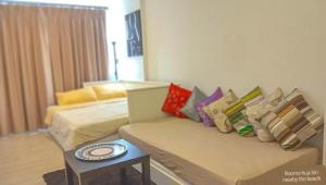 Cette chambre comprend deux lits, un canapé et une table. dans l'établissement Rooms hua hin nearby the beach, à Hua Hin