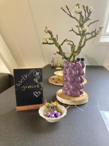 a purple cake sitting on a table next to a sign at De hoftuin Ilpendam appartement in Ilpendam +30 photos