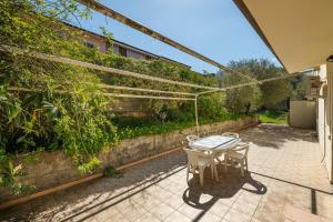 um pátio com uma mesa num jardim em Villa bifamiliare con giardino em Teulada