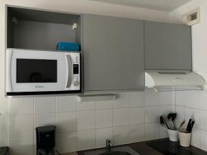 a kitchen with a microwave above a sink at STUDIO BORDEAUX in Bordeaux +2 photos