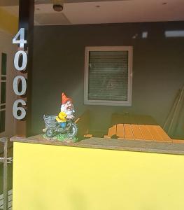 um gnomo sentado numa mota de brinquedo num balcão em Hiša Palček em Brezice