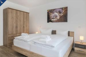 um quarto com uma cama branca e toalhas em An der Haffküste Otterhöhle em Zirchow