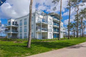 een wit gebouw met bomen ervoor bij An der Haffküste Otterhöhle in Zirchow