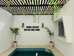 a swimming pool in a house with a sign on the wall at Sall Residence Mbour Saly in Mbour