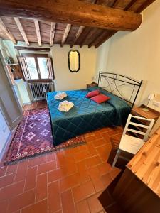 蓬塔謝韋的住宿－Agriturismo Tassinaia，一间卧室配有一张带蓝色床单和红色枕头的床。
