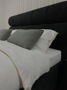 uma cama com uma cabeceira preta com almofadas em סוויטת Gadish em Bete-Seã