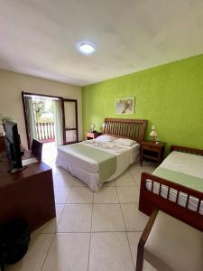 a bedroom with two beds and a television in it at Pousada Finlândia in Penedo