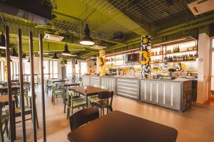 um restaurante com mesas e cadeiras e um bar em Lecco Hostel & Rooms em Lecco