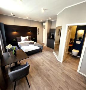 una habitación de hotel con una cama y una mesa y una habitación en Liro Hotel Oberhausen, en Oberhausen