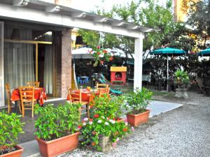 een patio met een tafel, stoelen en planten bij Hotel Garden in Tirrenia