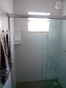 una doccia con porta in vetro in bagno di Village Jardins a Jacobina