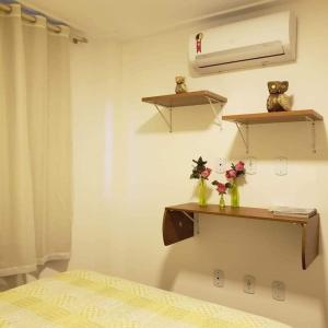 una camera da letto con scaffali e un letto con fiori di Village Jardins a Jacobina