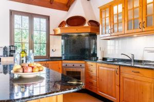 a kitchen with wooden cabinets and a bowl of fruit on a counter at Casa Simón in Fátaga