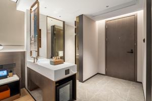 a bathroom with a fireplace and a sink and a mirror at Yizhi Hotel - Guangzhou East Railway Station Tianhe Sports Center in Guangzhou