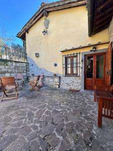 a stone patio with benches and a building at Agriturismo Tassinaia in Pontassieve