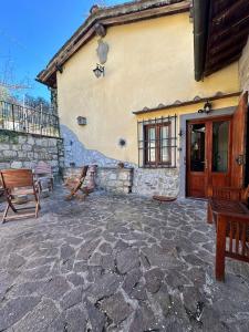 eine Steinterrasse mit Bänken und ein Gebäude in der Unterkunft Agriturismo Tassinaia in Pontassieve