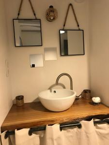 a bathroom with a white bowl sink on a wooden counter at Maison à la Campagne in La Chapelle-dʼAngillon
