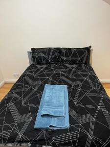 ein schwarzes und weißes Bett mit einem blauen Objekt darauf in der Unterkunft Nice house near cricket ground in Nottingham