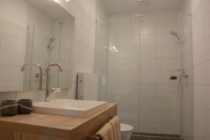 a bathroom with a sink and a shower and a toilet at Gästehaus Familie Gebhard Schädle in Grän