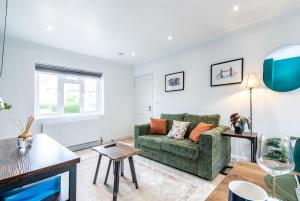 uma sala de estar com um sofá verde e uma mesa em 3 Bedroom Terraced House in Beeston Ideal for Corporate Stays em Beeston