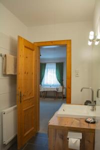 a bathroom with a sink and a door to a room at Gästehaus Familie Gebhard Schädle in Grän