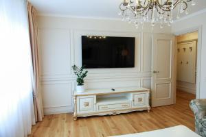 a living room with a tv on a wall at Boutique Apartments Siguldas in Liepāja