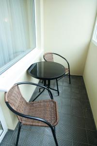 a table and two chairs and a table and a window at Boutique Apartments Siguldas in Liepāja +6 photos