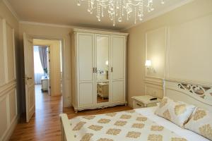 a bedroom with a bed and a chandelier at Boutique Apartments Siguldas in Liepāja