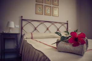a bedroom with a bed with a red flower on it at B&b Regina in San Miniato