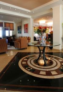 un vestíbulo con una mesa con un jarrón de flores. en Sea View Resorts & Spa en Karfas