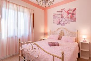 蒙特卡洛Casa di Nonna Tosca Montecarlo的卧室配有白色的床和粉红色的墙壁
