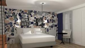 um quarto com uma cama branca e um papel de parede floral em Gabriel Hotel Chinon em Chinon