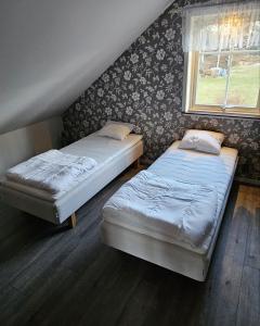 two twin beds in a room with a window at Guesthouse Erlandseröd in Strömstad