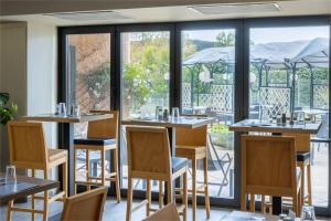 un restaurant avec des tables et des chaises et un balcon dans l'établissement Noemys Toulon La Valette - Hotel restaurant avec piscine, à La Valette-du-Var
