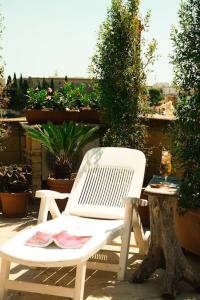 AdelfiaにあるAttico Oasi di Relax Adelfiaの白い椅子(植物のあるパティオに座る)