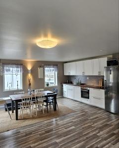 a kitchen and dining room with a table and refrigerator at Guesthouse Erlandseröd in Strömstad