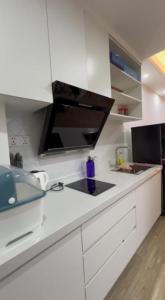 a kitchen with white cabinets and a black counter top at Morgan Enmaison in Phnom Penh