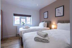 um quarto com 2 camas e toalhas em 3 Bedroom Terraced House in Beeston Ideal for Corporate Stays em Beeston