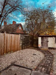 a backyard with a wooden fence and a building at Holiday House Near Football Ground in Nottingham