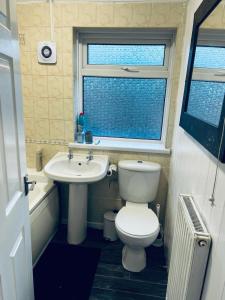 a small bathroom with a toilet and a sink at Holiday House Near Football Ground in Nottingham