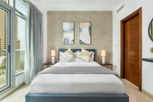 - une chambre avec un grand lit et une grande fenêtre dans l'établissement Ultimate Stay / Full Marina Views / High Floor / Perfect Vacation / Infinity Pool / 6 People, à Dubaï