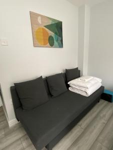a couch in a room with a painting on the wall at Budget City Center Apartment Aldgate - Tower Bridge in London