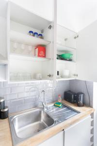 a kitchen with a stainless steel sink and white cabinets at Budget City Center Apartment Aldgate - Tower Bridge in London