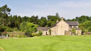 an old stone house with a large grass yard at Oak Tree Farm in Buxton
