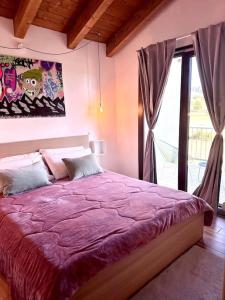- une chambre avec un lit violet et une fenêtre dans l'établissement Vista suggestiva sulle montagne!, à Ovindoli
