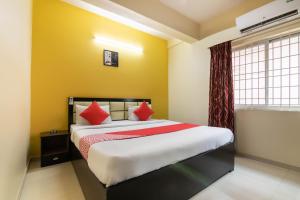 een slaapkamer met een groot bed met rode kussens bij OYO Hotel Royal INN Near Nexus Mall Koramangala in Bangalore