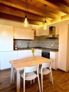 uma cozinha com uma mesa de madeira e cadeiras brancas em Vista suggestiva sulle montagne! em Ovindoli