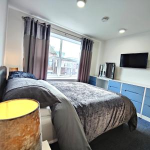 a bedroom with a bed and a tv and a window at Liverpool Stays - Kempston Court in Liverpool
