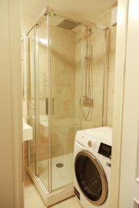 een wasmachine in een badkamer met een douche bij Boutique Rooms Dzintaru in Liepāja