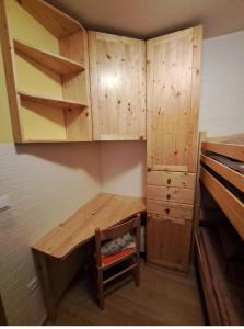 een kleine kamer met een houten bureau en kasten bij Hiša Palček in Brežice